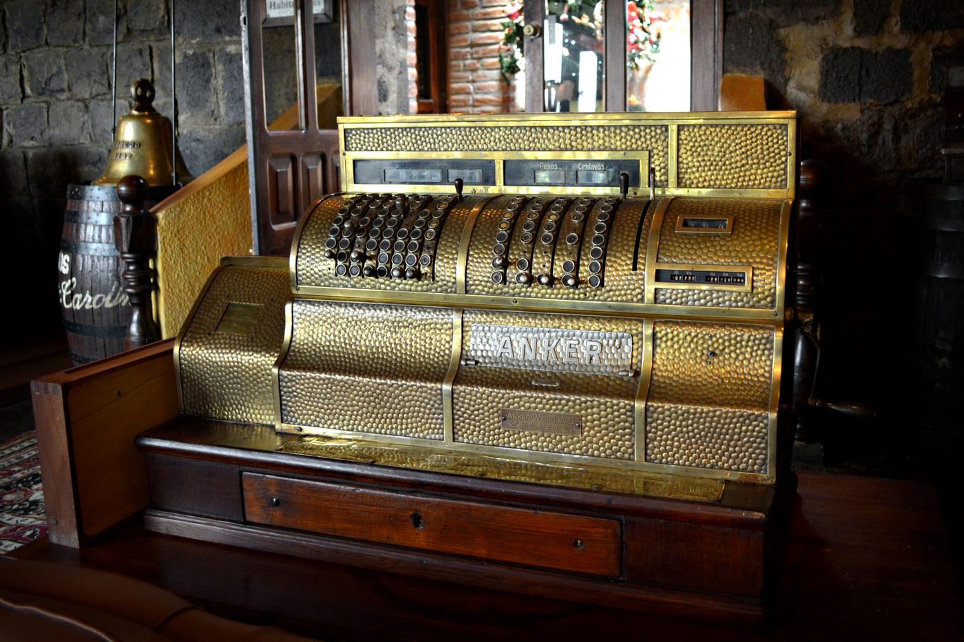 Caja registradora antigua de bronce con el marcador de pesos y centavos.