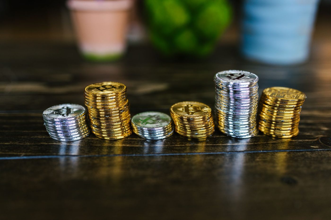 Torres de monedas apiladas sobre una mesa de madera