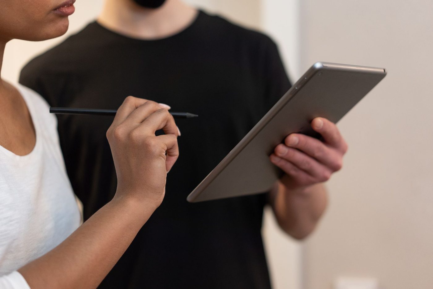 Persona con un lápiz junto a una tableta digital