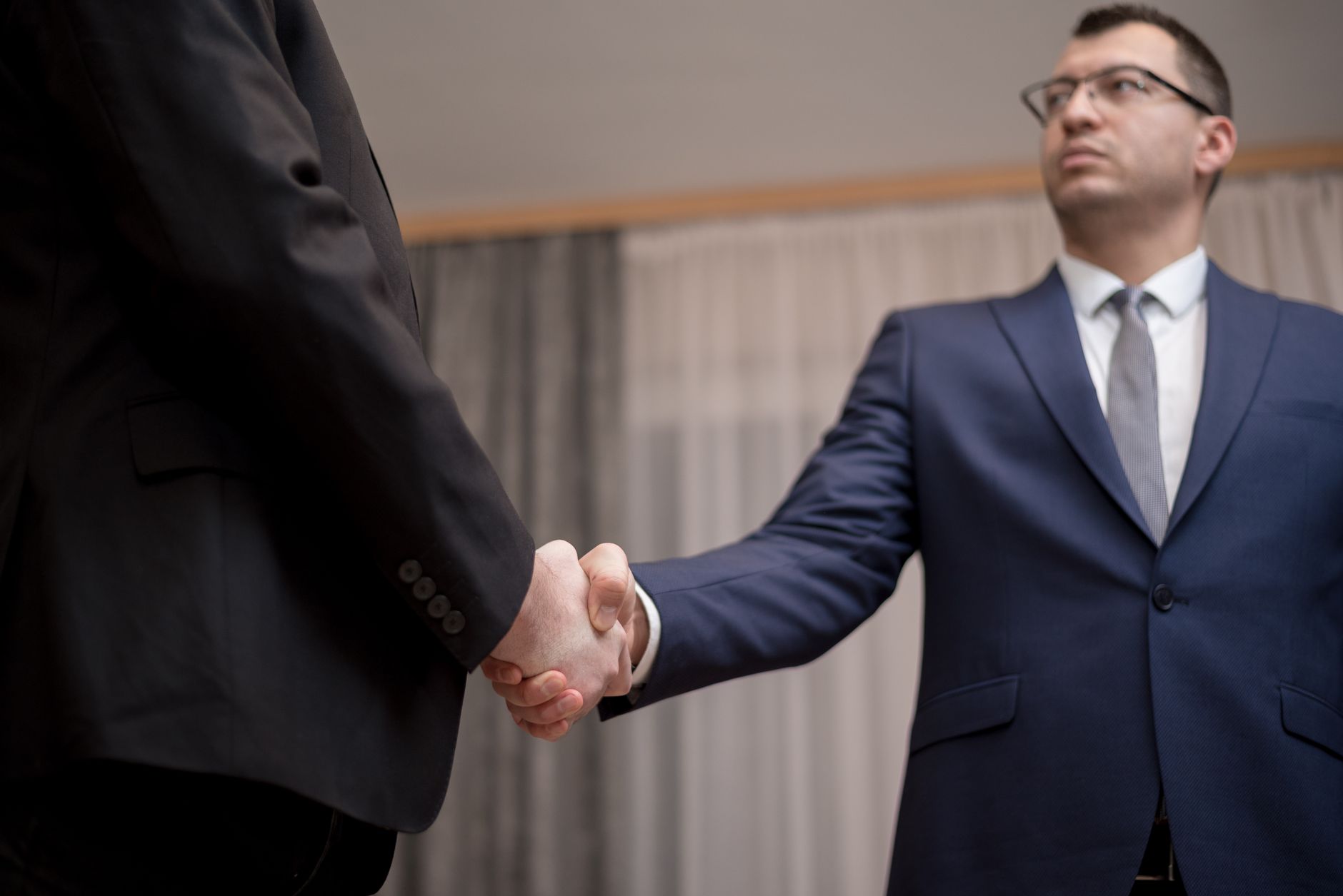 Dos personas se dan la mano tras cerrar un acuerdo comercial.